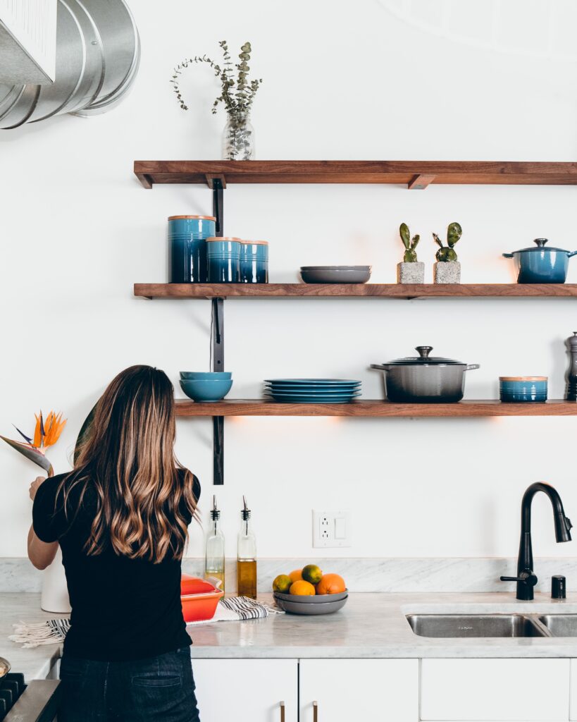 Woman organising flowers in front of organised shelves